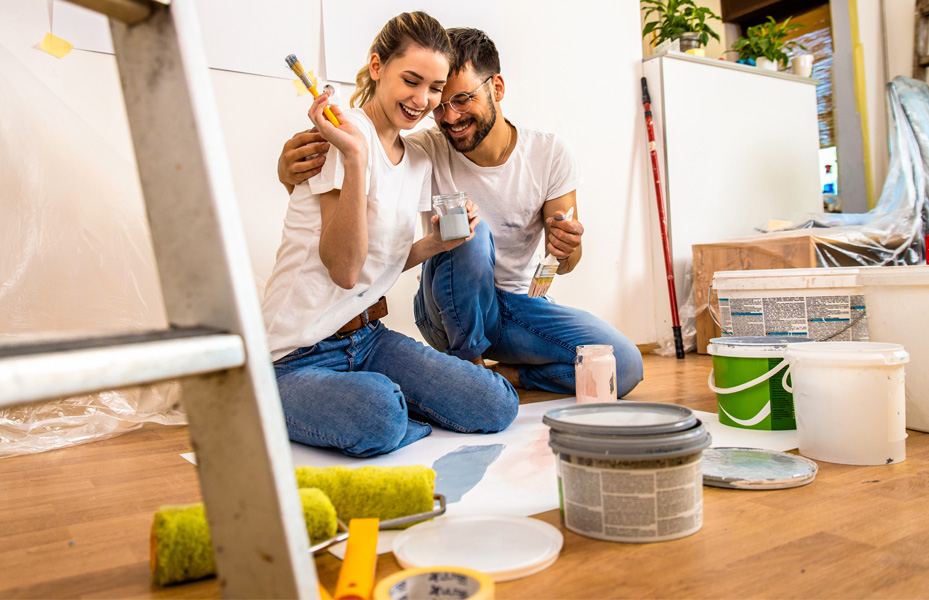 Man and woman laughing while painting