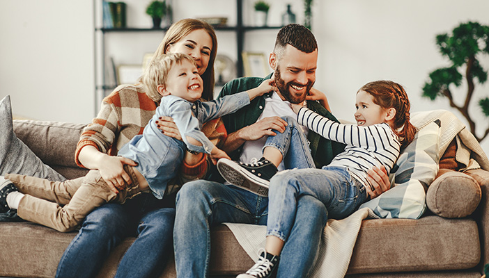 Family hugging on a couch smiling