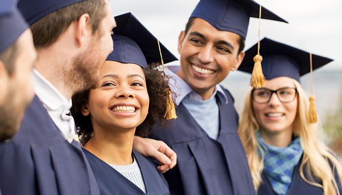 Student wearing graduation robes smiling